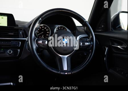 Derby, Regno Unito - 19 settembre 2025: Volante BMW, con l'iconico logo BMW Roundel, pulsanti multifunzione integrati Foto Stock