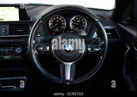 Derby, Regno Unito - 19 settembre 2025: Volante BMW, con l'iconico logo BMW Roundel, pulsanti multifunzione integrati Foto Stock