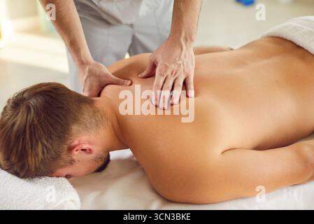 Terapista professionista che esegue un massaggio alla schiena Foto Stock