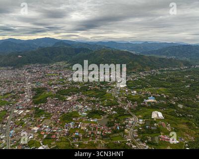 Vista aerea della città in una valle tra terreni agricoli e montagne. Takengon, Sumatra. Indonesia. Foto Stock