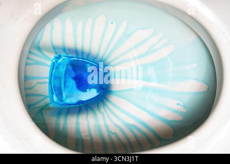 Vista ravvicinata della vaschetta del water durante la pulizia con sapone detergente blu. Sfondi a tema per le pulizie Foto Stock