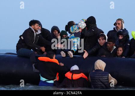 Un gruppo di persone ritenute migranti si tuffò nel mare vicino a Gravelines in Francia per salire su una barca. Data foto: Venerdì 19 settembre 2025. Foto Stock