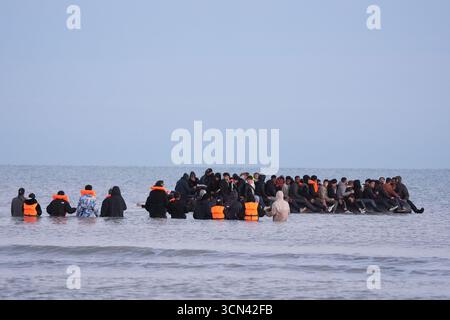 Un gruppo di persone ritenute migranti si tuffò nel mare vicino a Gravelines in Francia per salire su una barca. Data foto: Venerdì 19 settembre 2025. Foto Stock