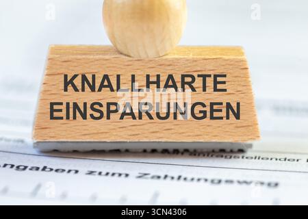 (Montaggio fotografico) primo piano di un francobollo con l'iscrizione KNALLHARTE EINSPARUNGEN Foto Stock