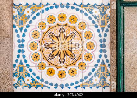 Mattonelle di ceramica azulejo portoghesi con intricati motivi a forma di stella e fiori nei colori blu, giallo e rosa di Porto, Portogallo Foto Stock