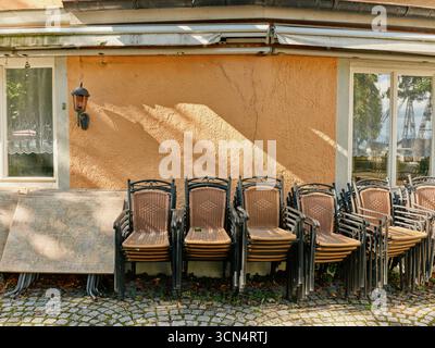 Sedie e tavoli impilati all'esterno del ristorante chiuso a lindau, germania Foto Stock