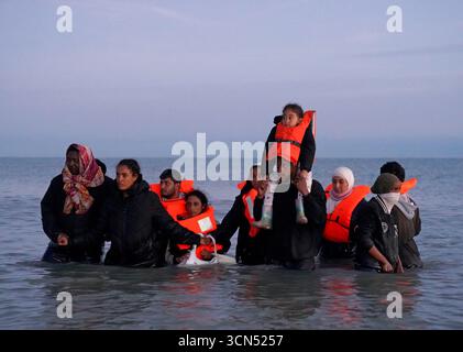 Un gruppo di persone ritenute migranti si tuffò in mare per incontrare una piccola barca a Gravelines, in Francia. Data foto: Venerdì 19 settembre 2025. Foto Stock