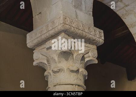 Veduta di una colonna di pietra intagliata, il suo capoluogo corinzio adornato con foglie di acanto, in silenzio splendore, Bominaco, Abruzzo, Italia. Foto Stock