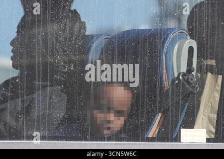 NOTA PER i REDATTORI: I volti dei bambini sono stati pixellati in quanto il Picture Desk della PA non è stato in grado di ottenere il permesso necessario per fotografare un bambino sotto i 16 anni su questioni riguardanti il loro benessere. Un gruppo di persone ritenute migranti in partenza in autobus dal complesso Border Force di dover, nel Kent, a seguito di un piccolo incidente in barca nel Canale. Data foto: Venerdì 19 settembre 2025. Foto Stock