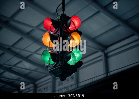 Semaforo che mostra tutti i colori. I semafori rossi, gialli (ambra) e verdi brillano in un tunnel. Incertezza: Devo fermarmi o andare? Foto Stock