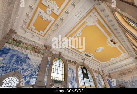 Portogallo, Porto, stazione ferroviaria di Sao Bento costruita nei primi anni del XX secolo con il suo tetto colorato e alcuni dei grandi pannelli di circa ventimila piastrelle azulejo disegnati e dipinti da Jorge Colaco. Foto Stock