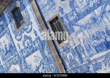 Portogallo, Porto, parete laterale dell'azulejo del XVIII secolo rivestita Capela das Almas o Cappella delle Anime, ma conosciuta anche come Cappella di Santa Catarina con 15.947 piastrelle azulejo disegnate da Eduardo Leite. Foto Stock