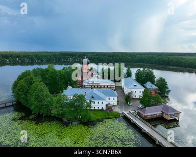 Un'ampia ripresa aerea del monastero dell'isola di Vvedensky, situato su una piccola isola in un lago, con due ponti pedonali che lo collegano alla riva. Foto Stock