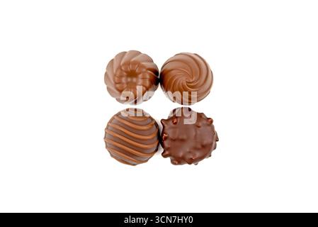 Quattro caramelle al cioccolato con giravoldi. Le caramelle sono disposte in una piazza. Le caramelle sono marroni e hanno un aspetto delizioso Foto Stock