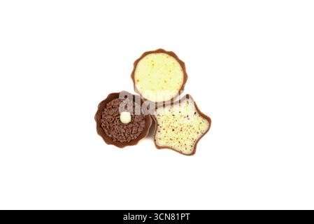 Su sfondo bianco vengono visualizzate tre diverse prelibatezze di cioccolato. I dolcetti sono disposti in una formazione triangolare, con uno di essi Foto Stock