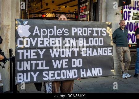 Gli attivisti hanno organizzato una protesta fuori dall'Apple Store in Regent Street, nel centro di Londra, il 17 settembre durante il lancio dell'iPhone 17. I manifestanti hanno tenuto manifesti che dichiaravano “iPhone 17 coperto di sangue”, accusando Apple di trarre profitto dalle miniere di cobalto in Congo legate al lavoro minorile e alle violazioni dei diritti umani. Le code dei clienti che tentavano di entrare nell'Apple Store di Regent Street sono state incontrate con canti, cartelloni e spettatori che si sono riuniti per assistere alla protesta. Foto Stock