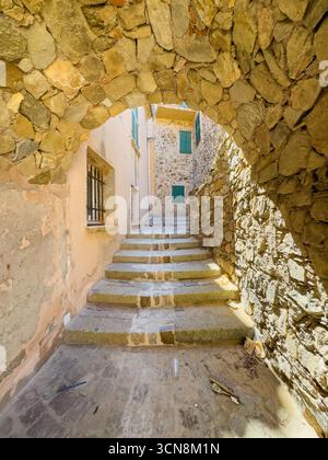 Saint Tropez, Francia - 13 luglio 2024: Scenario del centro. Il vicolo conduce verso sud da Plage de la Glaye al centro città. Primo piano con gradini, pareti laterali e. Foto Stock