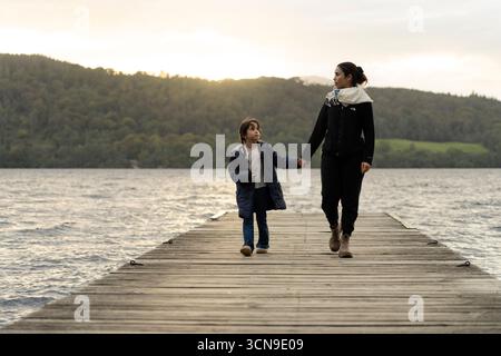 Madre e figlia sul molo di Lake Windermere, Lake District, Cumbria, Inghilterra, Regno Unito Foto Stock