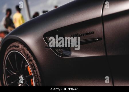 Milano, italia 20 settembre 2025: Parafango laterale mercedes-amg gt con emblema biturbo v8, finitura nera opaca e parte del cerchio arancione Foto Stock