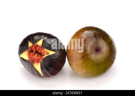 Vengono mostrati due fichi maturi, uno dei quali tagliato a metà. L'altro è intero Foto Stock