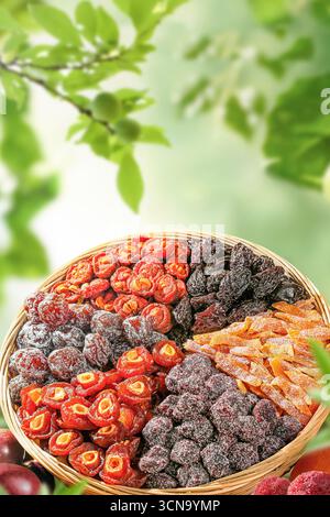 Assortimento di frutta secca in scatola di legno, spuntino sano, cibo naturale, frutta fresca e secca vibrante in cesto rustico contro il cielo soleggiato Foto Stock