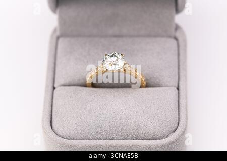 Un anello di diamante bianco e oro è in una scatola. L'anello è un simbolo di amore e impegno Foto Stock