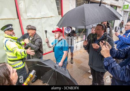 La polizia cerca di respingere gli streamer. Combatti contro il razzismo contro la polizia e gli streamer di Altrincham. Una strada principale, George Street, fu bloccata in quanto i due gruppi di manifestanti furono bloccati nella città mercato a sud del centro di Manchester. I manifestanti di Stand Up to Racism sono stati separati da una linea di polizia e respinti dalla polizia lontano dai manifestanti di destra. Gli streamer di destra hanno molestato la protesta urlando abusi durante le riprese. Altrincham Manchester foto: Garyrobertsphotografia. Foto Stock