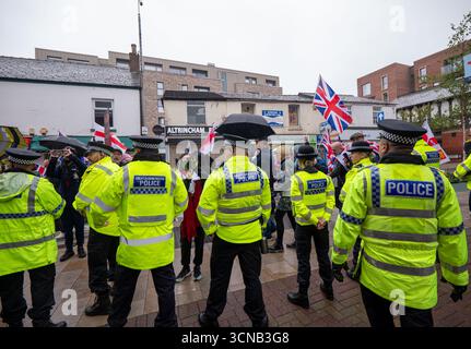 Combatti contro il razzismo contro la polizia e gli streamer di Altrincham. Una strada principale, George Street, fu bloccata in quanto i due gruppi di manifestanti furono bloccati nella città mercato a sud del centro di Manchester. I manifestanti di Stand Up to Racism sono stati separati da una linea di polizia e respinti dalla polizia lontano dai manifestanti di destra. Gli streamer di destra hanno molestato la protesta urlando abusi durante le riprese. Altrincham Manchester foto: Garyrobertsphotografia. Foto Stock
