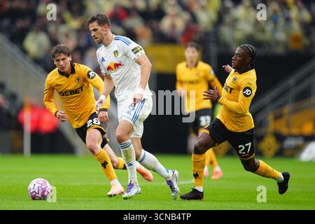 Anton Stach del Leeds United (a sinistra) e Jean-Ricner Bellegarde del Wolverhampton Wanderers (a destra) combattono per il pallone durante la partita di Premier League al Molineux Stadium di Wolverhampton. Data foto: Sabato 20 settembre 2025. Foto Stock