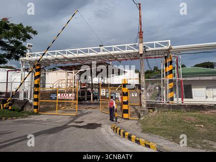 Batangas, regione di Calabarzon, Filippine. 20 settembre 2025. Cancello d'ingresso della LMG Land Development Corporation a Pinamucan, Batangas City, con un portatubi sopraelevato che attraversa la strada di accesso; le condutture collegano il sito direttamente a un molo nella baia. L'impianto ospita serbatoi di stoccaggio industriali e impianti portuali utilizzati per il petrolio e i prodotti chimici (Chemoil e Unioil sembrano operare sul sito). Crediti: Kevin Izorce/Alamy Live News Foto Stock