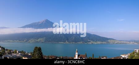 Band nuvola mattutina sul lago di Zugo con Rigi Peak sulle Alpi svizzere sullo sfondo Foto Stock
