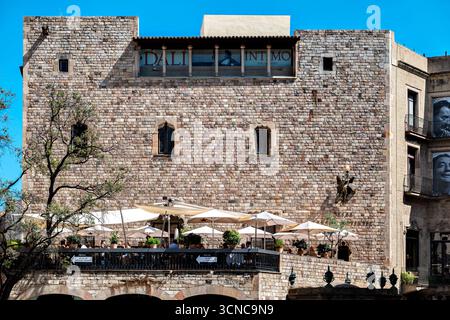 Barcellona, Spagna, 2 agosto 2025: I residenti e gli ospiti della città si rilassano in un accogliente caffè nella giornata di sole, sulla terrazza in pietra nella parte vecchia della città. Foto Stock