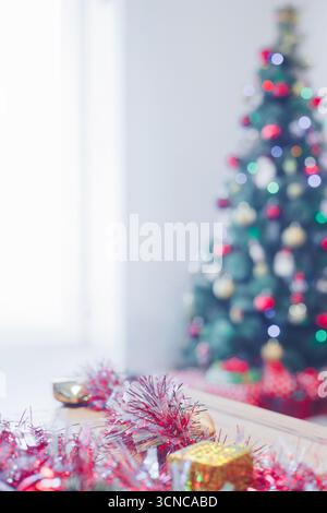 Regali natalizi e un albero di Natale accanto a una grande finestra Foto Stock