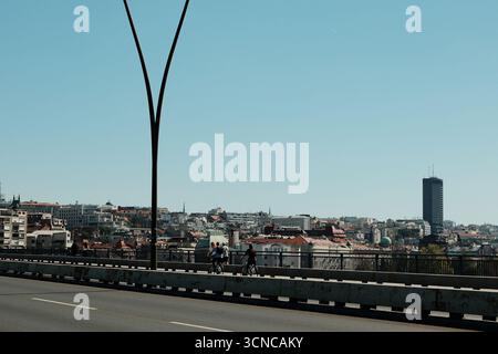 Belgrado, Serbia - 20 settembre 2025. Ciclisti che attraversano il ponte Brankov con edifici cittadini e alte torri in vista. Foto Stock