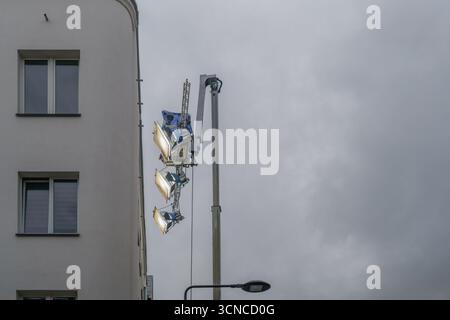 Set cinematografico per l'illuminazione di una gru urbana con luci professionali montate sul braccio di sollevamento accanto all'edificio residenziale per la produzione di video cinematografici Foto Stock