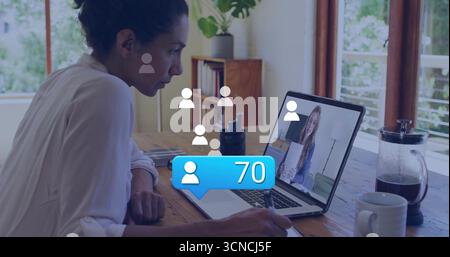 Scrivere un lavoratore remoto utilizzando una penna sulla scrivania dell'ufficio di casa con un computer portatile che mostra il collega e la pressa per caffè Foto Stock