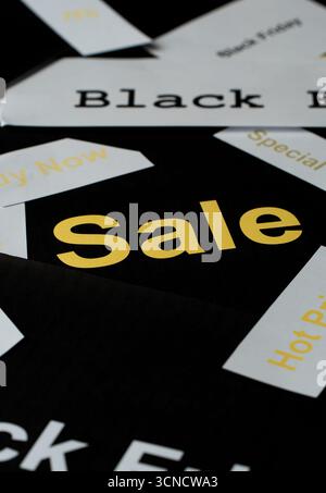 Una pila di segni neri e gialli con la parola sale scritta in giallo. I segni sono sparsi su uno sfondo nero Foto Stock