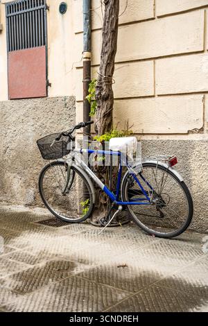 Bicicletta appoggiata contro un muro , che mette in risalto la mobilità sostenibile e le pittoresche strade, nel centro storico di Pistoia, Toscana, Italia Foto Stock