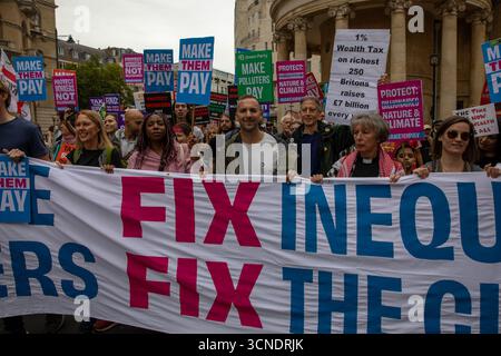 Londra, Regno Unito. 20 settembre 2025. Gli attivisti marciano dietro un banner "Tax the Rich" durante una dimostrazione. I manifestanti marciarono da Portland Place a Whitehall nella protesta "Make Them Pay: Tax the Super Rich", tenendo striscioni che chiedevano miliardari e inquinatori a pagare il conto per i servizi pubblici. Credito: SOPA Images Limited/Alamy Live News Foto Stock