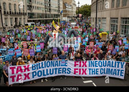 Londra, Regno Unito. 20 settembre 2025. Gli attivisti marciano dietro un banner "Tax the Rich" durante una dimostrazione. I manifestanti marciarono da Portland Place a Whitehall nella protesta "Make Them Pay: Tax the Super Rich", tenendo striscioni che chiedevano miliardari e inquinatori a pagare il conto per i servizi pubblici. Credito: SOPA Images Limited/Alamy Live News Foto Stock