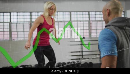 Bilanciare la donna con l'abbigliamento atletico eseguendo esercizi di step in palestra, con piattaforma e grafico verde Foto Stock