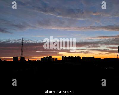 alba sulla città, splendidi raggi dorati del sole che sorge sulla città addormentata Foto Stock
