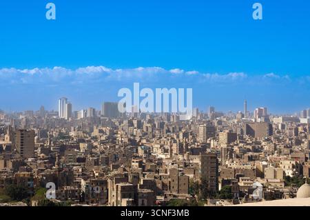Vista panoramica del Cairo, Egitto, catturata dalla storica Cittadella, che mostra la densa architettura urbana sotto un cielo azzurro. Foto Stock