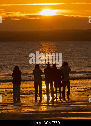 Portobello, Edimburgo, Scozia, Regno Unito. 21 settembre 2025. Alba fredda a 6 gradi centigradi dal Firth of Forth. Nella foto: I turisti asiatici osservano il sorgere del sole e scattano fotografie accanto al Firth of Forth. Credito: Arch White/alamy notizie dal vivo. Foto Stock