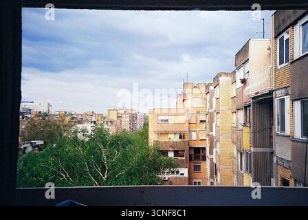 Foto analogica della lavanderia appesa ad asciugare su un balcone. Uno sguardo tranquillo sulla vita di tutti i giorni, incorniciato da luce, consistenza e quiete domestica. Foto Stock