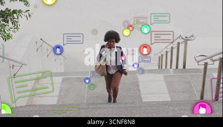 Un dirigente che porta una borsa da viaggio che parla sullo smartphone salendo gradini di pietra che mostrano avvisi Foto Stock