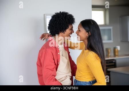 Diverse coppie all'interno di una moderna cucina casalinga appoggiate l'una verso l'altra da vasetti portaoggetti Foto Stock