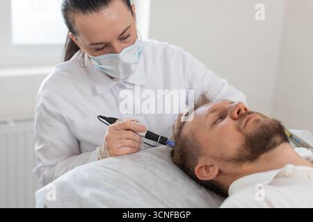 Alopecia. Perdita di capelli uomo migliorare la rigenerazione del trattamento di crescita, dermapen microneedling, vitamine esosomi iniezioni di plasma. Cosmetologo tricologo medico procedura cuoio capelluto mesoterapia frazionaria Foto Stock