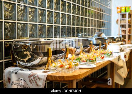 catering, buffet sul tavolo. Diversi tipi di tartine, mini insalate e spuntini. Bicchieri di vino. Foto di alta qualità Foto Stock