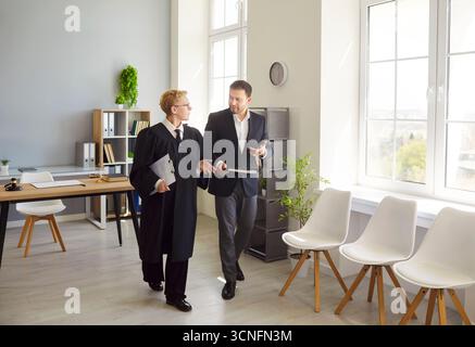 Donna in veste di giudice che trasporta documenti, consulenze legali prima di discutere seriamente per decidere il caso Foto Stock